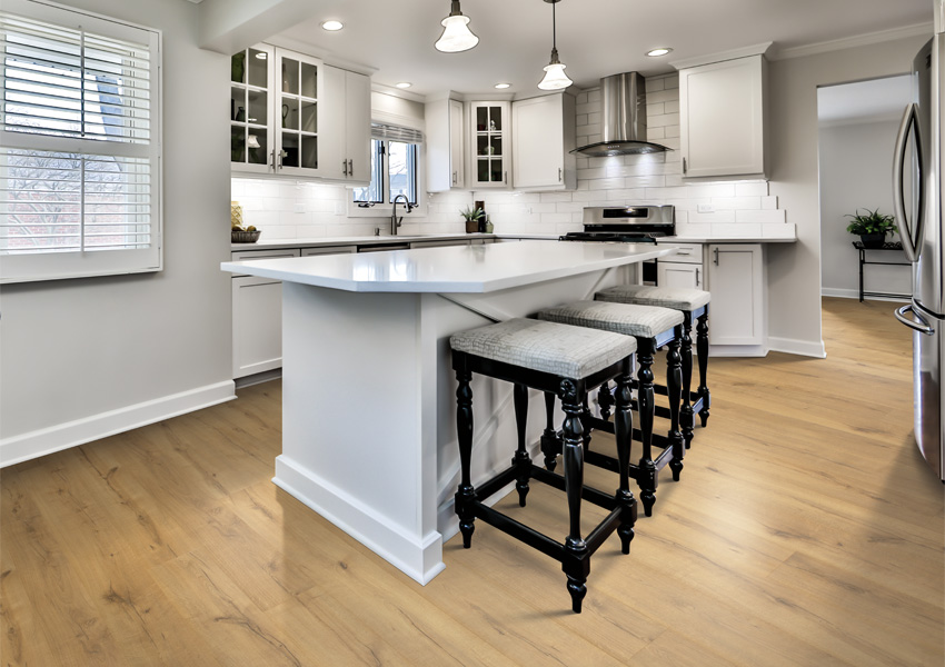 wood look laminate flooring in kitchen with kitchen island and black stools